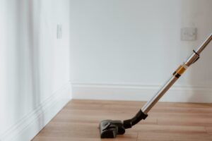 A vacuum cleaner in use on a wooden floor in a modern home.